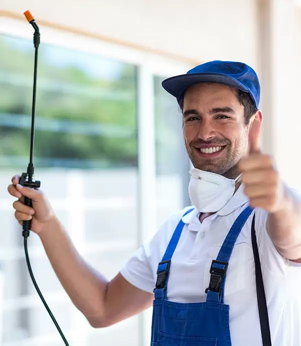 a man in overalls and a hat giving a thumbs up